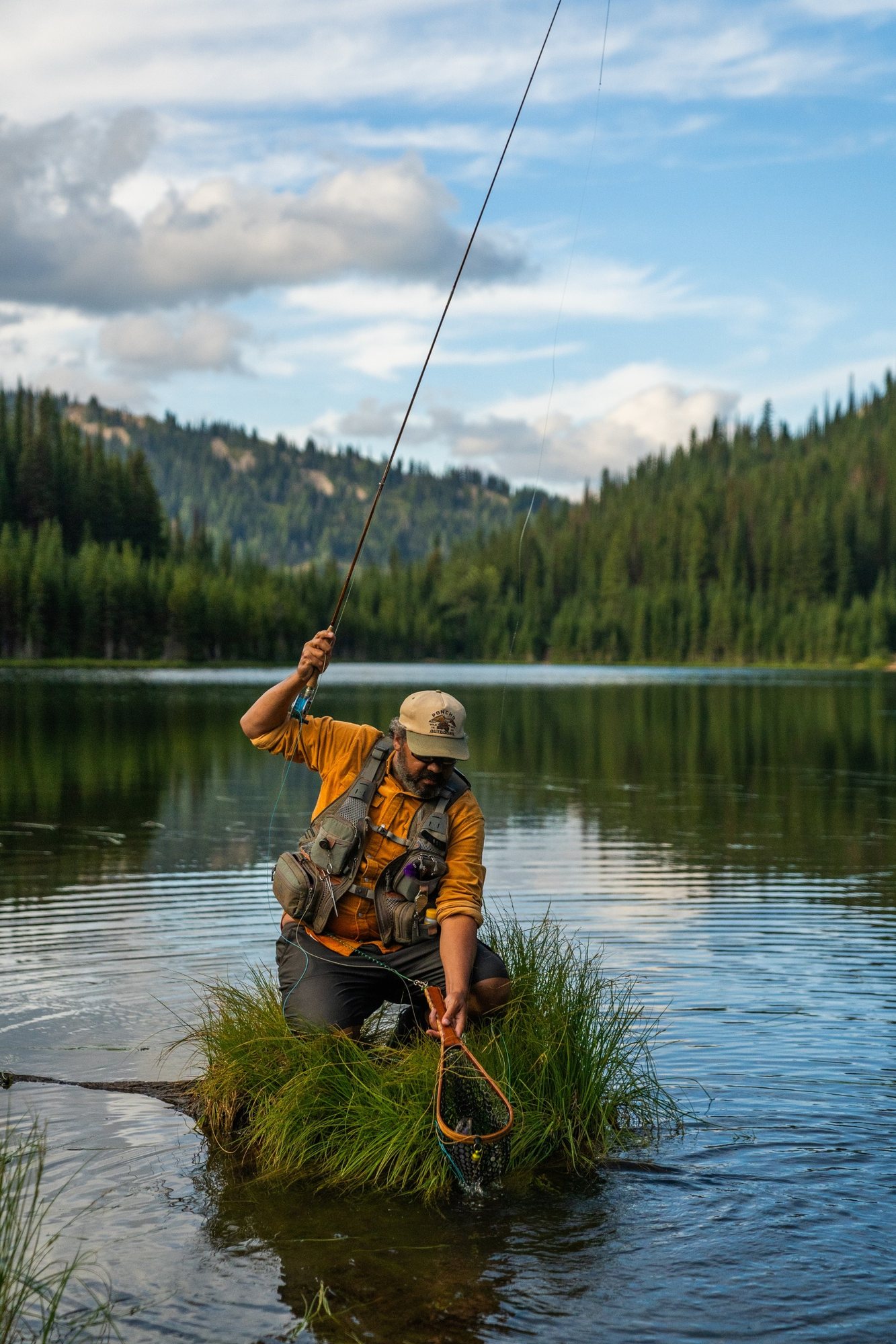 Josh Crumpton fly fishing from a grass island on a high mountain lake